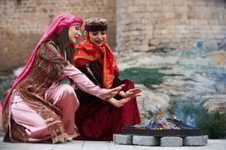 Beautiful Azeri Women in Traditional Azerbaijanz Dress Warming Hands Above the Bonfire