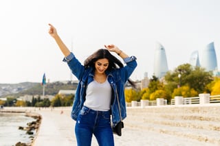 Happy Woman In A Jeans Jacket Walking Around The City