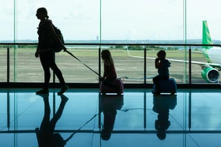 In Airport Transit Hall Young Mother Carries On Suitcases Little Kids To Departure Gate For