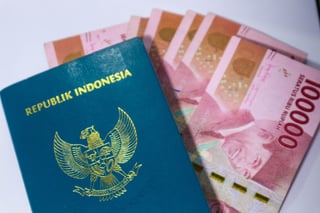 Indonesian Green Passport With A Collection Of Hundred Thousand Rupiah As The Background