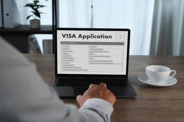 Man writing down personal details for a visa application