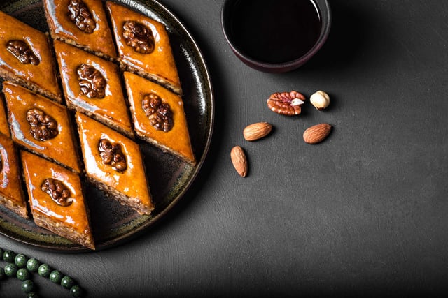 Baklava con nueces y miel sobre fondo negro