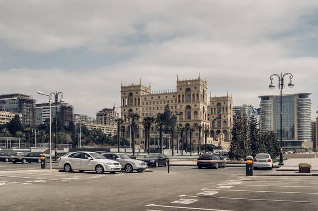 Coches en Bak&uacute; con paisaje urbano al fondo