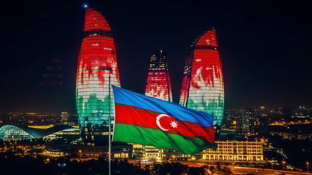 Vista nocturna de las Torres de Llamas con la bandera nacional