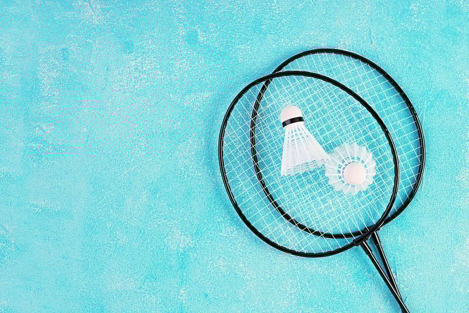 Shuttlecock And Badminton Rackets On A Blue Background