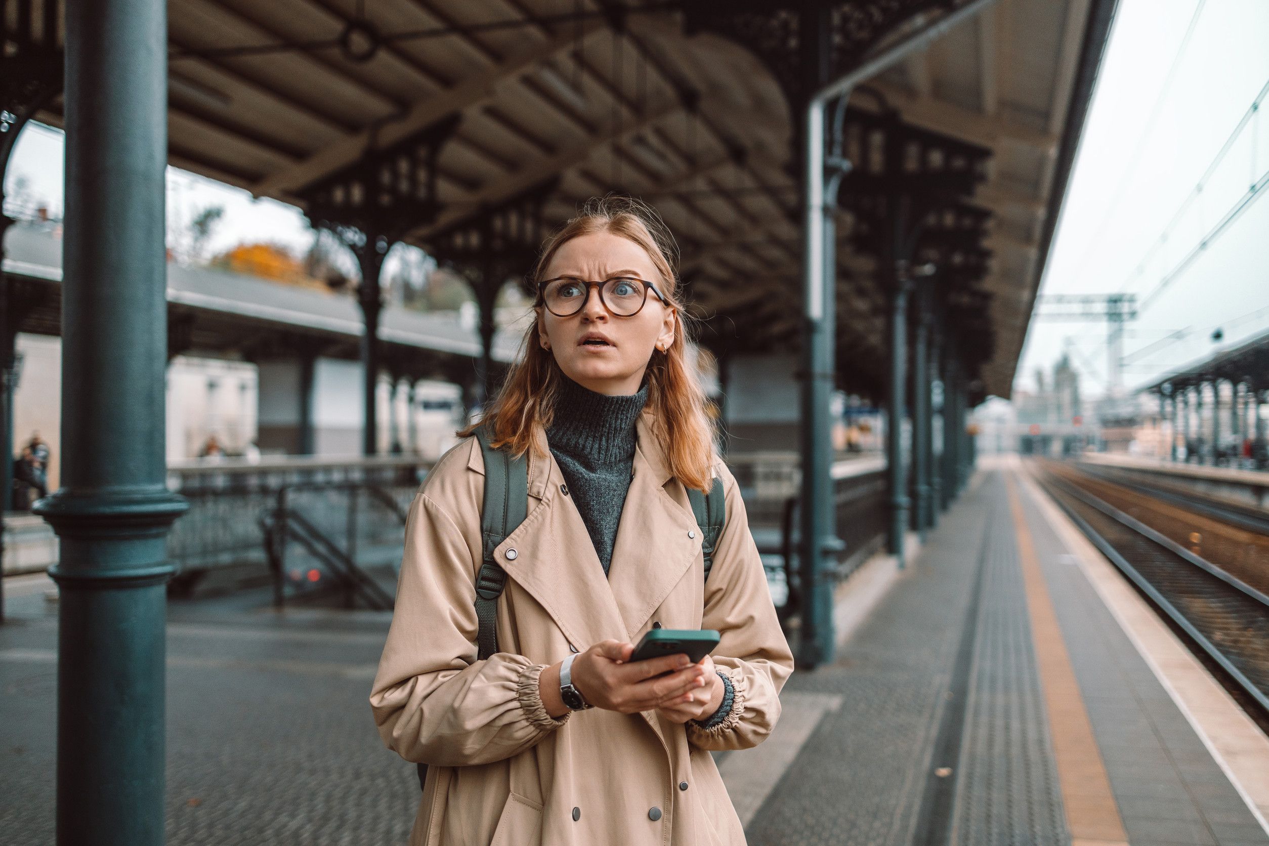 Femme perdue et en colère, seule sur le quai d'un train de transport en commun, attendant.