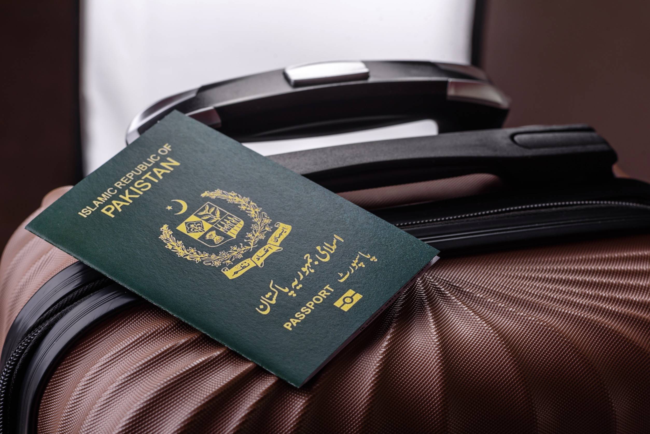Internationaler Pass eines Bürgers von Pakistan auf einem Koffer – Abreise vom Flughafen